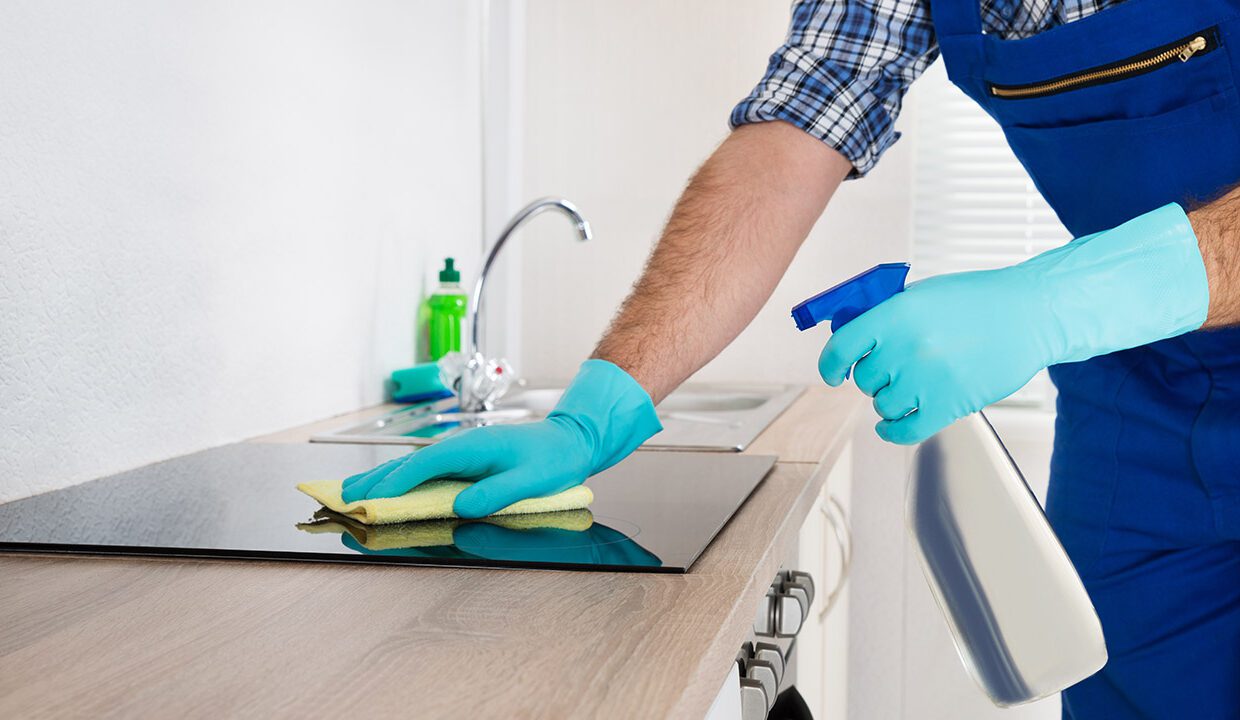 A person in blue gloves cleaning the counter.