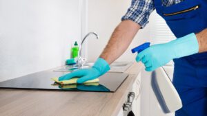 A person in blue gloves cleaning the counter.