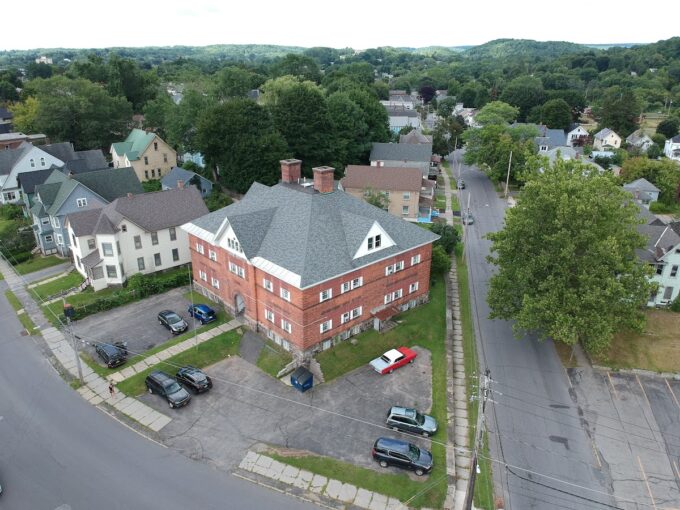 An aerial view of a building with cars parked in front.