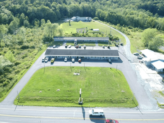 An aerial view of a parking lot with cars parked on the side.