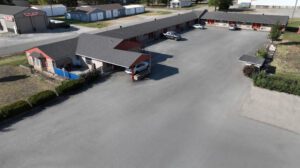 A motel with cars parked in front of it.